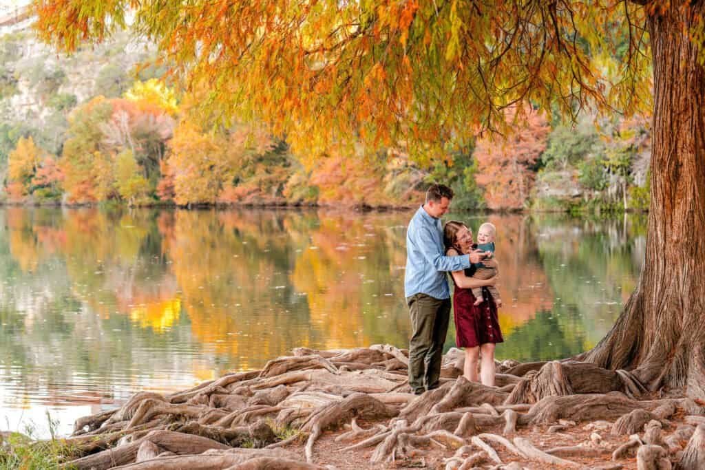 Elegant autumn family photos with vibrant fall foliage at a peaceful lakeside.