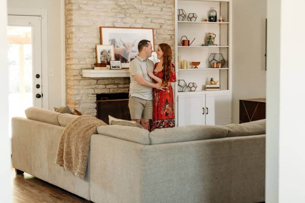 A couple posing for photos in their Austin home before their move