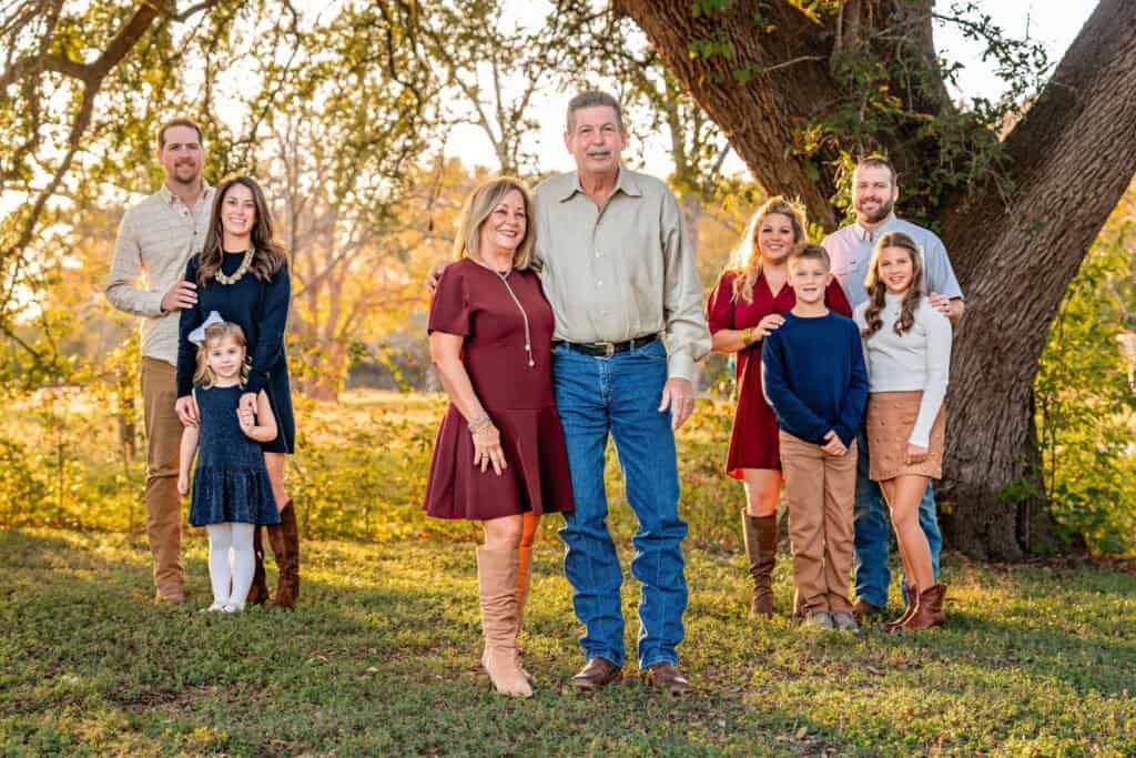 An extended family including grandparents, daughters, spouses, and grandchildren posing for a picture in Old Settlers Park