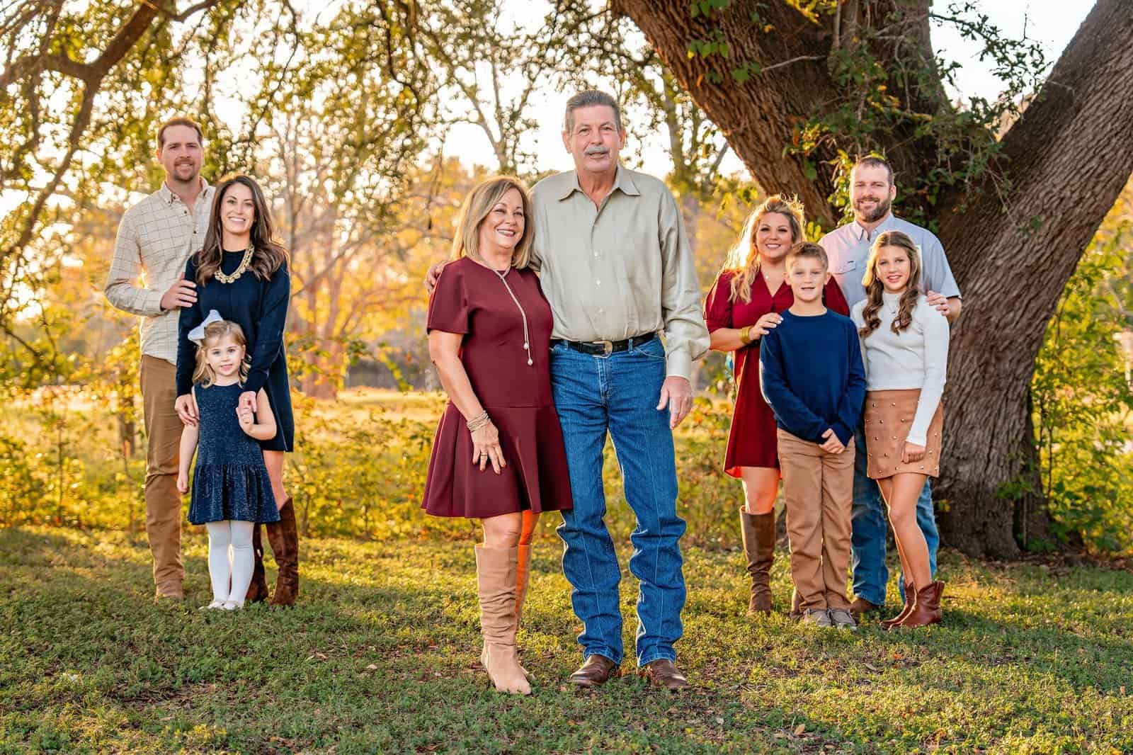 An extended family including grandparents, daughters, spouses, and grandchildren posing for a picture in Old Settlers Park