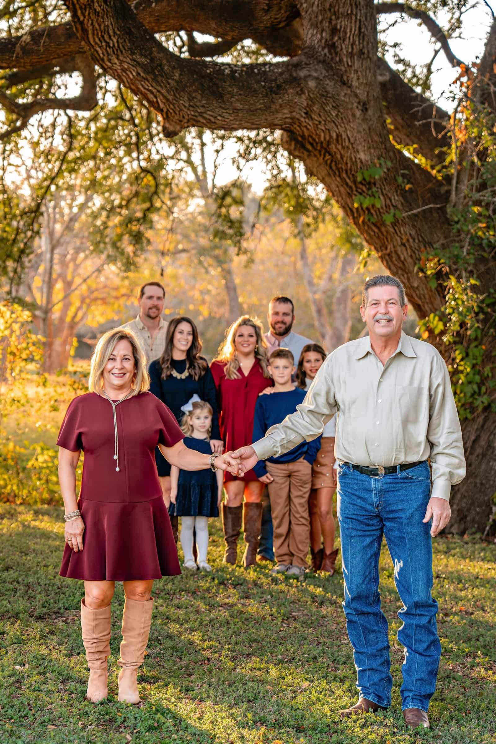 An extended family including grandparents, daughters, spouses, and grandchildren posing for a picture in Old Settlers Park