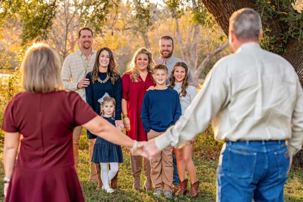 An extended family including grandparents, daughters, spouses, and grandchildren posing for a picture in Old Settlers Park